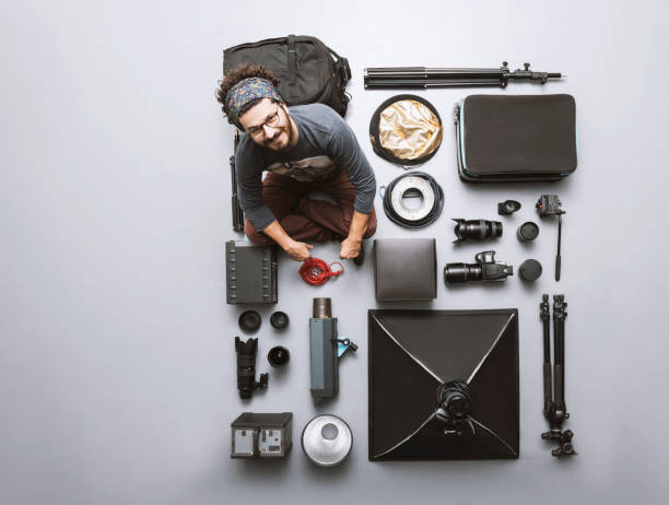 Photographer posing with his cameras and photographic studio equipments